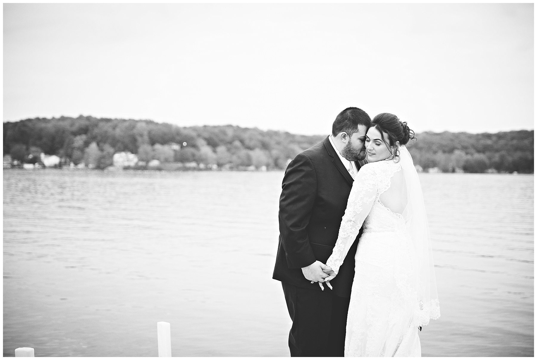 Black and white photo of bride and groom on the dock at Bay Pointe Inn on Gun Lake photographed by Melissa Gregersen Photography