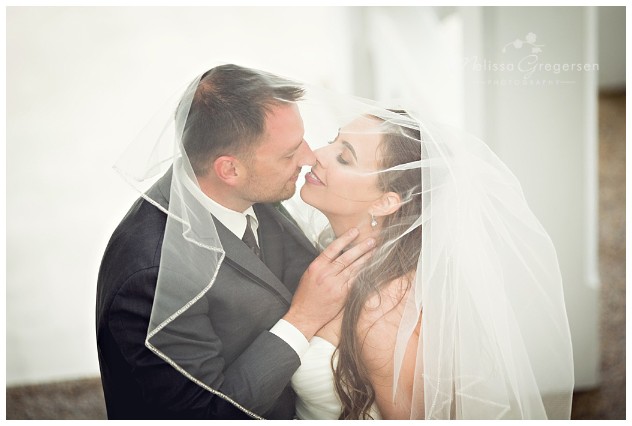 Kissing under the veil at their wedding at Bay Pointe Inn