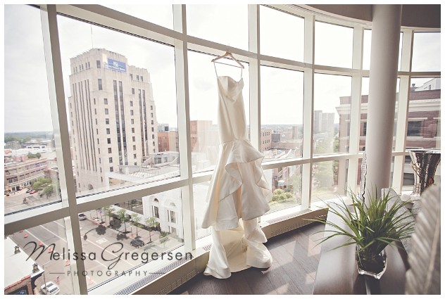 bridal gown hanging in the window of the Grand Loft Suite at the Radisson