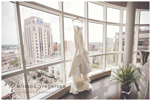  bridal gown hanging in the window of the Grand Loft Suite at the Radisson