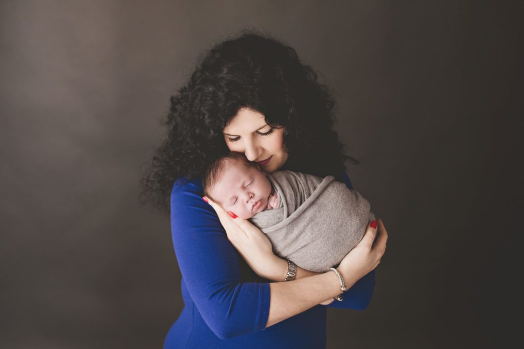 Beautiful mother snuggling her newborn baby son