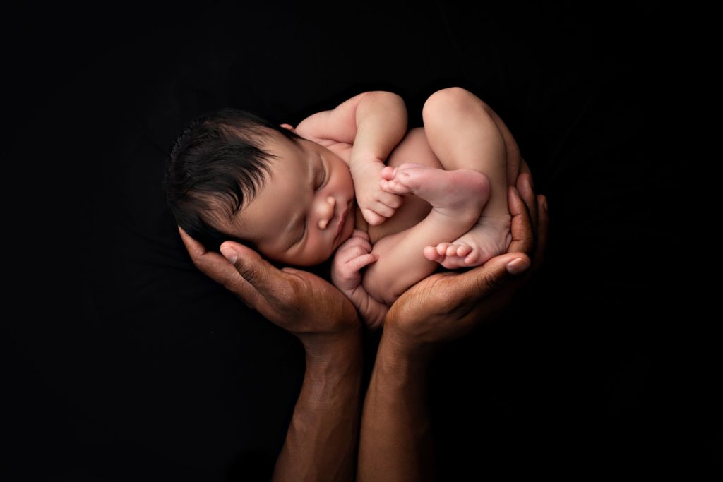 Newborn baby girl in daddy's arms at Gregersen Photography Studio