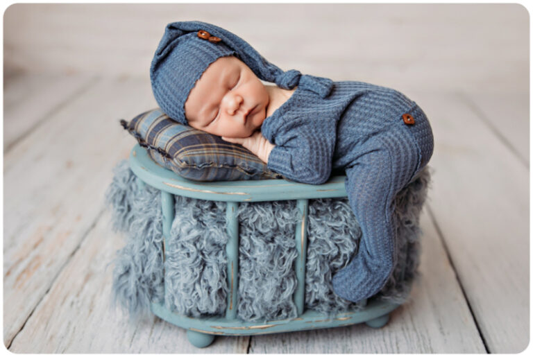 blue monochrome newborn baby boy sleeping in a bed.